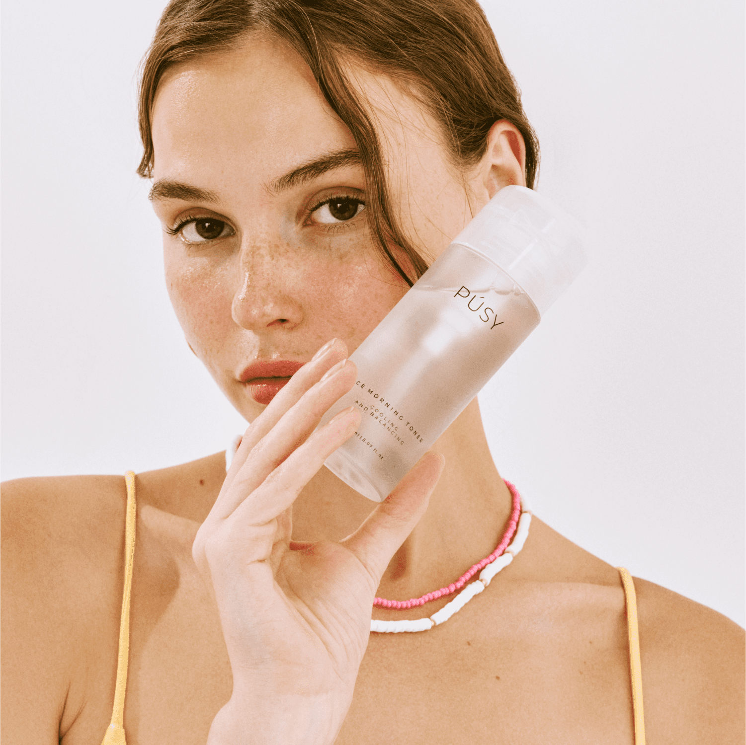 Woman using PÚSY Ice Morning Tonic — Professional cooling skincare routine